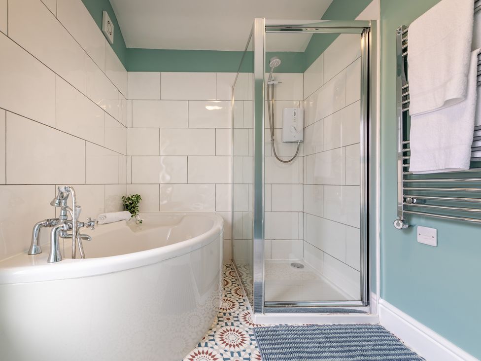 A bathroom with a bath tub and shower enclosure at 22 Ashville Avenue, Scarborough