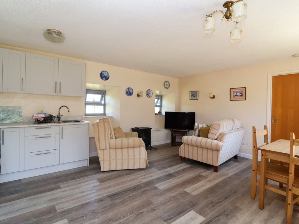 A living room with kitchen cabinets and a dining table at Chestnut in Weston-super-Mare