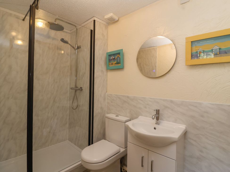 A bathroom featuring a shower, toilet, and sink at Chestnut in Weston-super-Mare