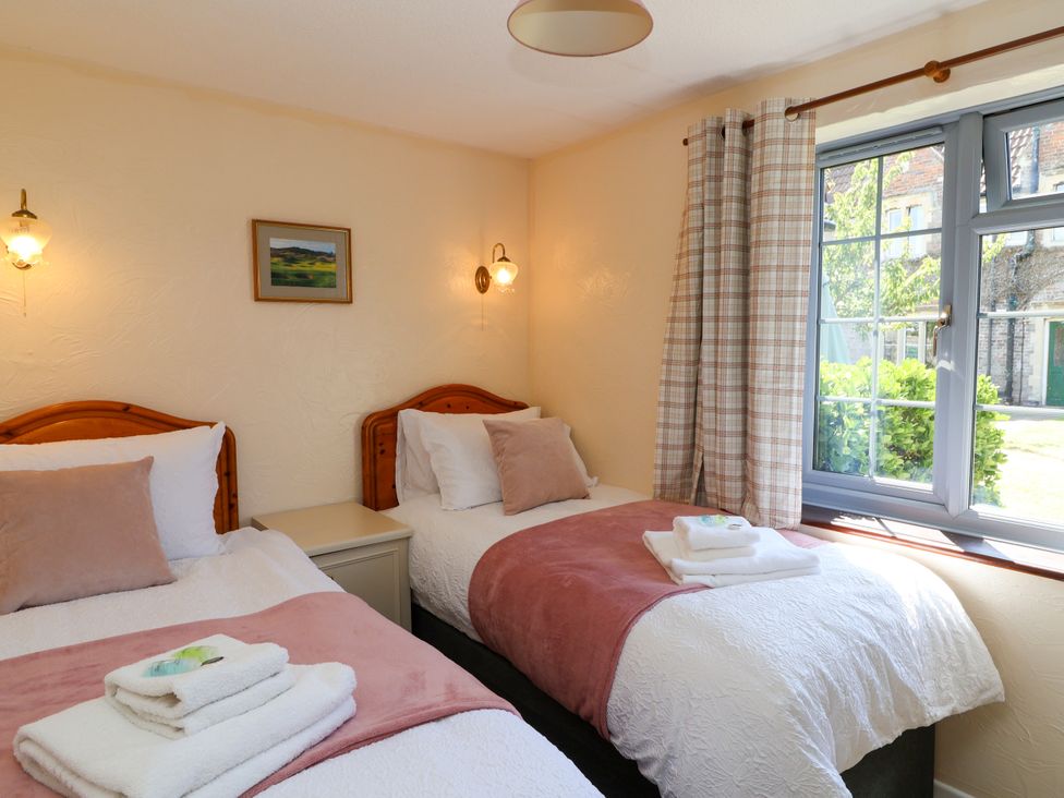 A bedroom with two beds and a window at Chestnut in Weston-super-Mare