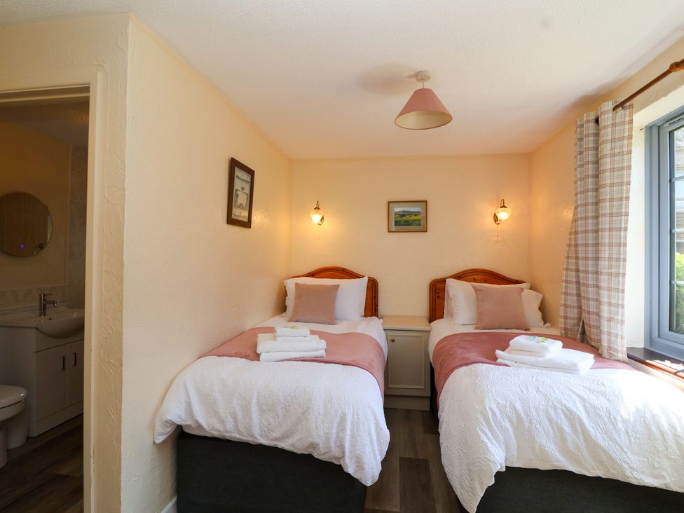 A bedroom with two beds and a bathroom area at Chestnut in Weston-super-Mare