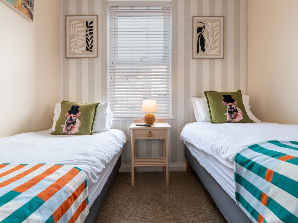 A bedroom with two beds and a bedside table at The Ravines in Scarborough
