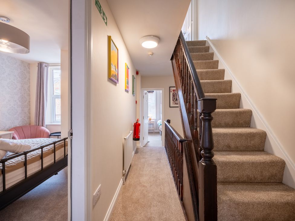 A hallway with a staircase and a bed at The Ravines in Scarborough