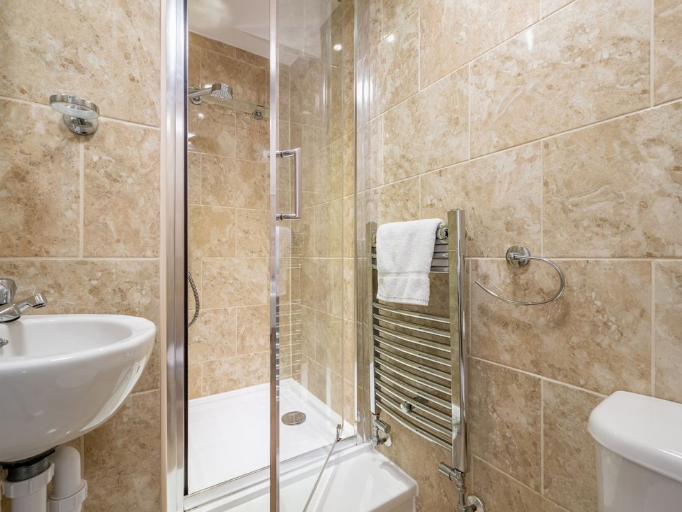 A bathroom with shower, sink, toilet and towel rail at The Ravines in Scarborough