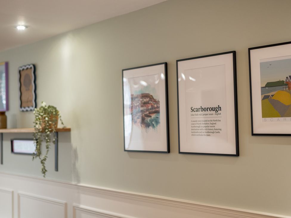A cozy wall with framed artwork and a shelf with a plant at The Ravines in Scarborough