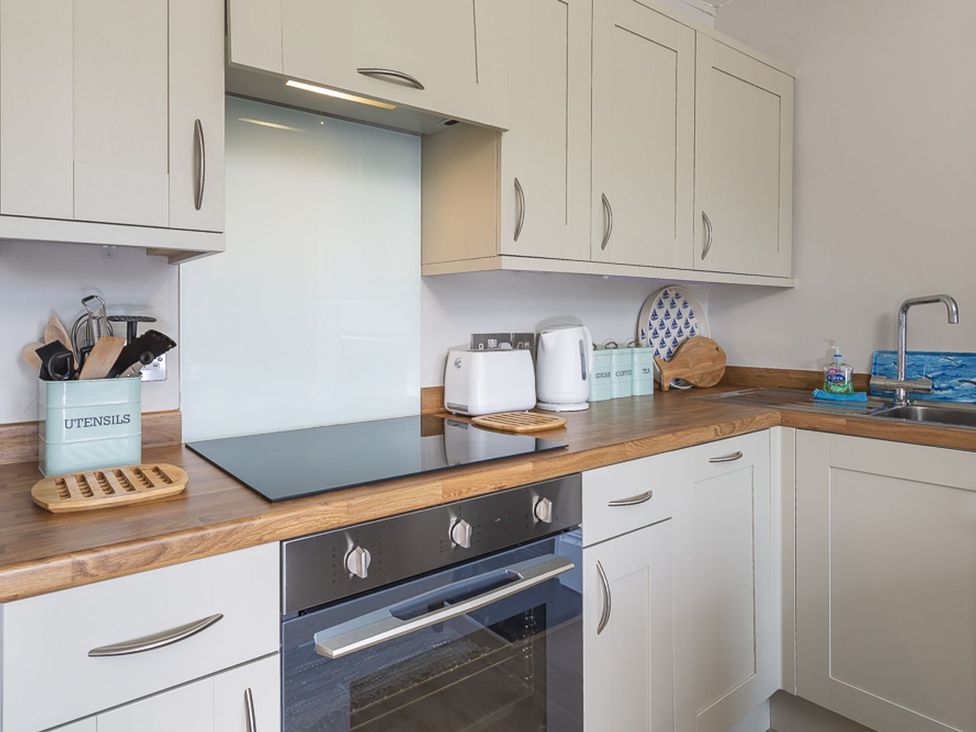 A kitchen with cabinets and a sink at Primrose Cottage Salcombe
