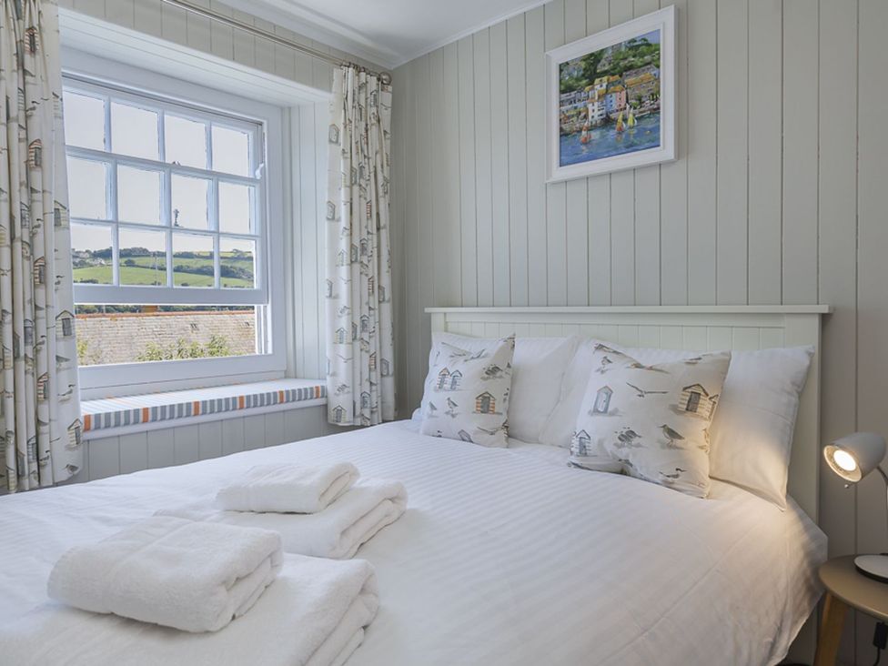 A bedroom with a bed and window at Primrose Cottage in Salcombe