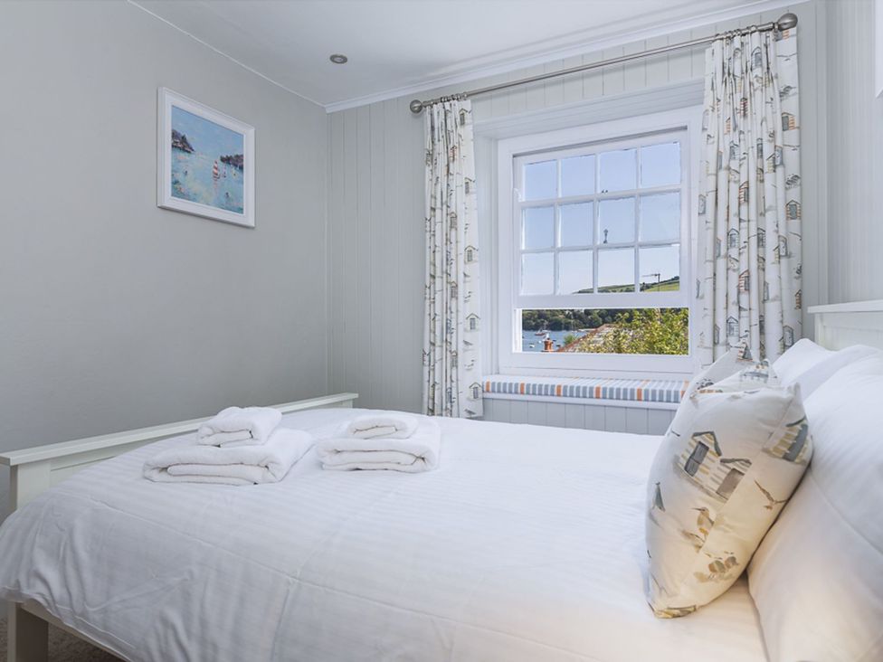 A bedroom with a bed and window at Primrose Cottage in Salcombe