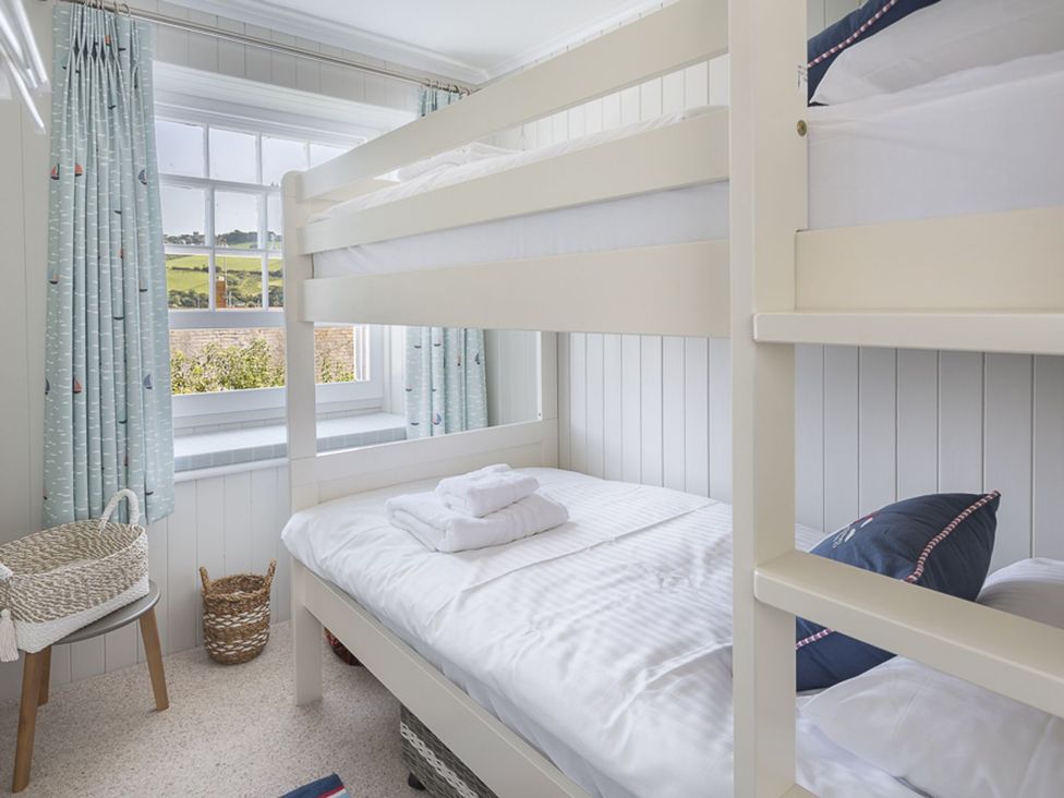 A bedroom with a bunk bed and window at Primrose Cottage in Salcombe