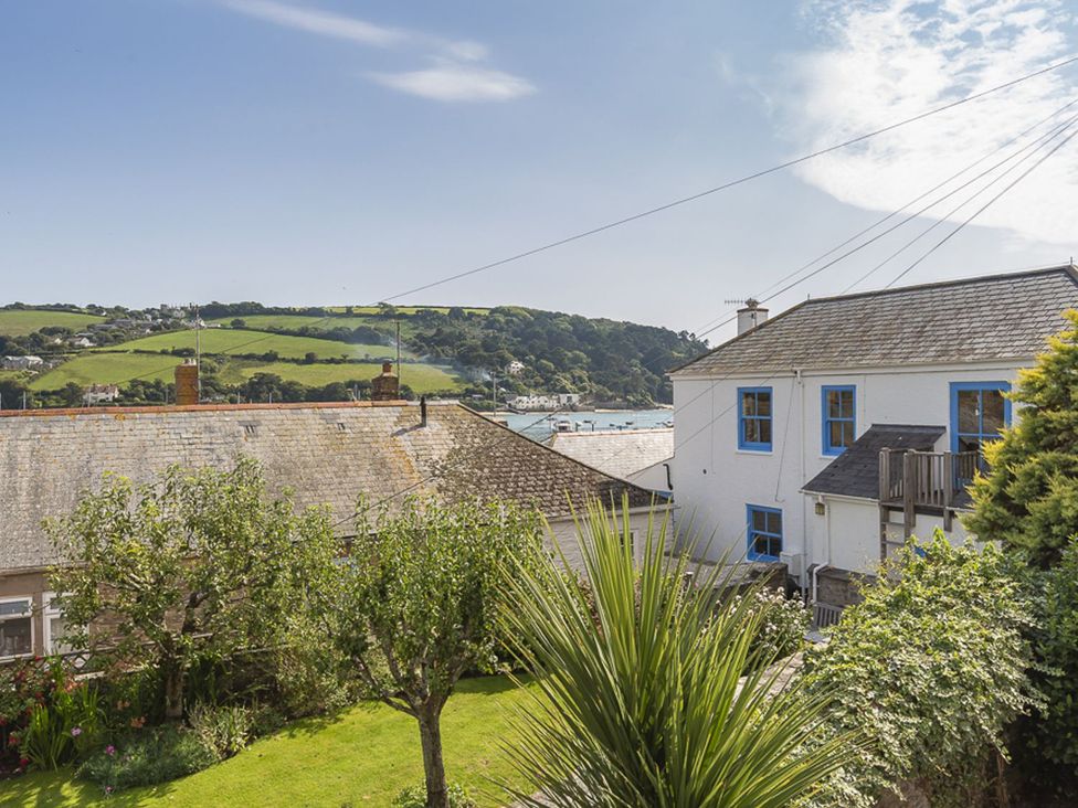 A view of houses and trees with hills in the background at Primrose Cottage Salcombe
