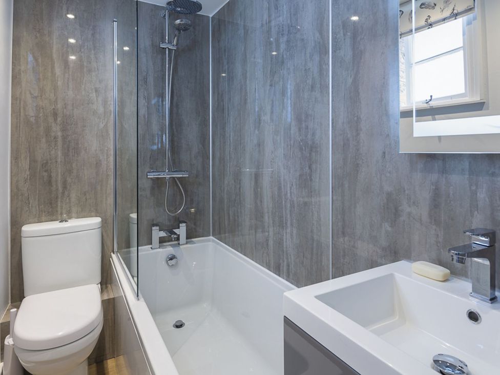 A bathroom with shower, bathtub, sink, and toilet at Primrose Cottage Salcombe