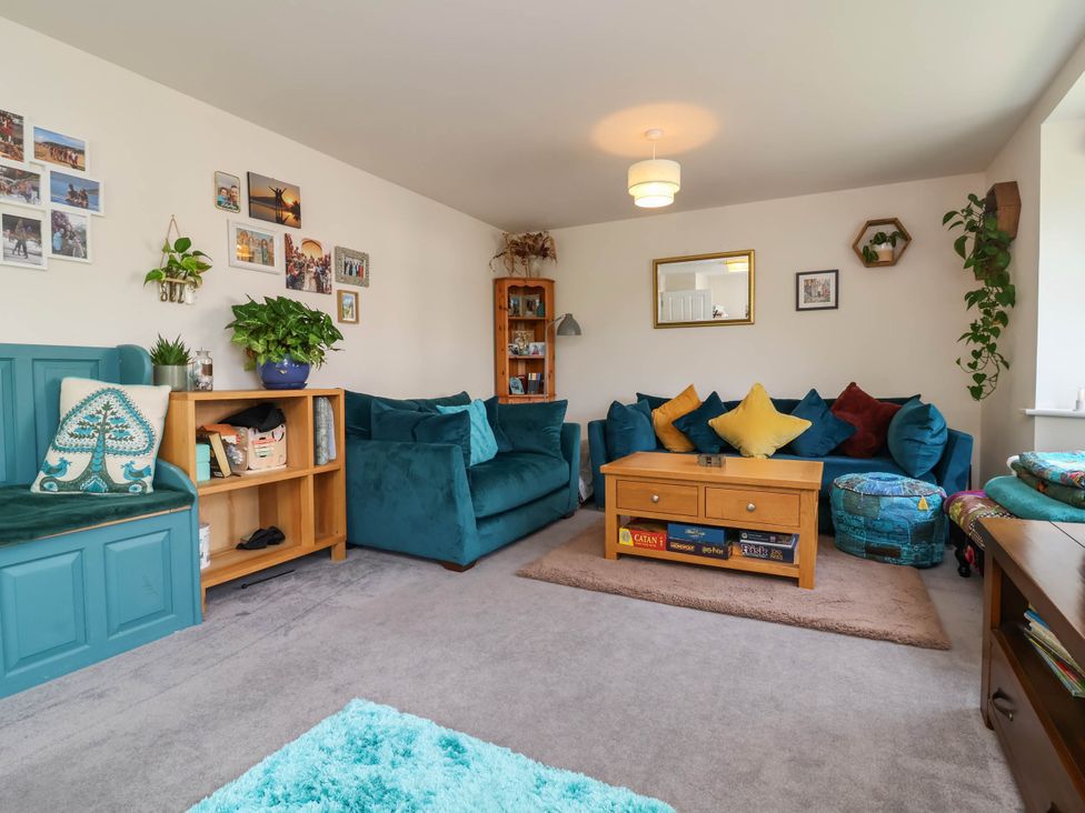 A living room with a sofa, coffee table and bookshelf at Manning's View in Barnstaple