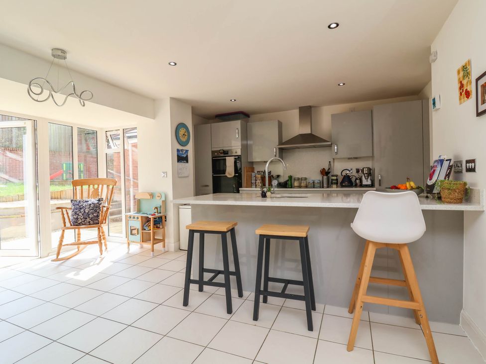 A kitchen with an island and stools at Manning's View in Barnstaple