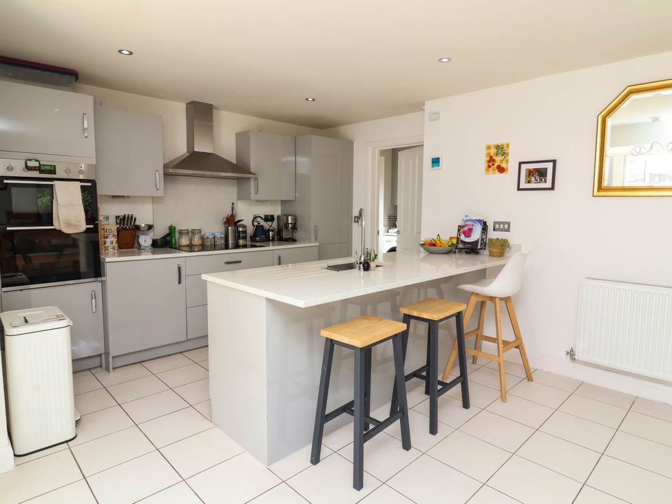 A kitchen with modern appliances and a bar area at Manning's View in Barnstaple