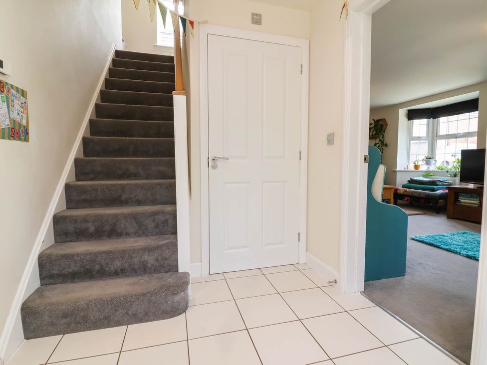 A hallway with stairs and a door at Manning's View Barnstaple