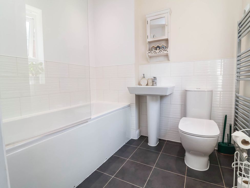 A bathroom featuring a bath tub, sink, and toilet at Manning's View in Barnstaple