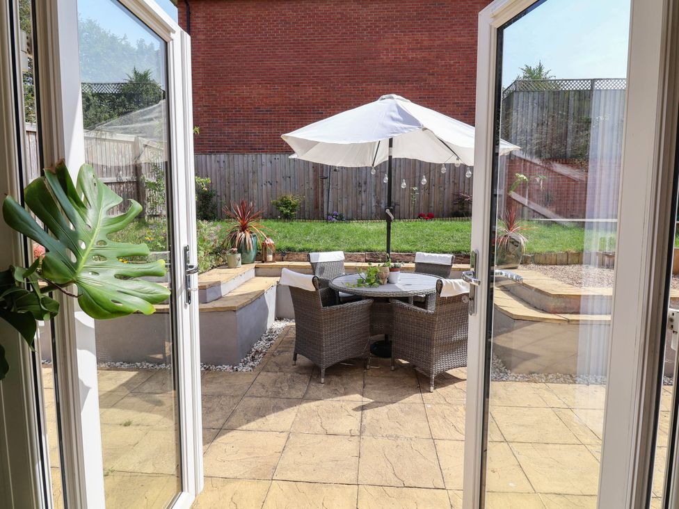 A garden with patio furniture and an umbrella at Manning's View in Barnstaple