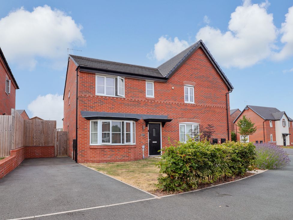 A house with a driveway and hedges at 12 Corbetts Close in Crewe