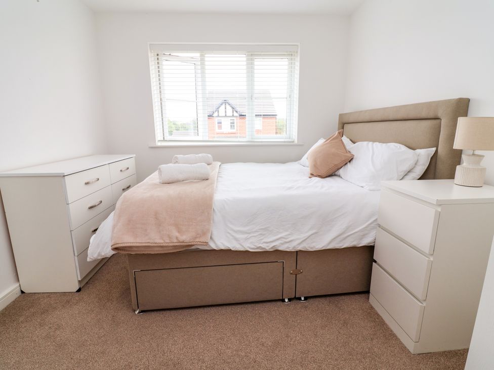 A bedroom with a bed and dresser at 12 Corbetts Close Crewe