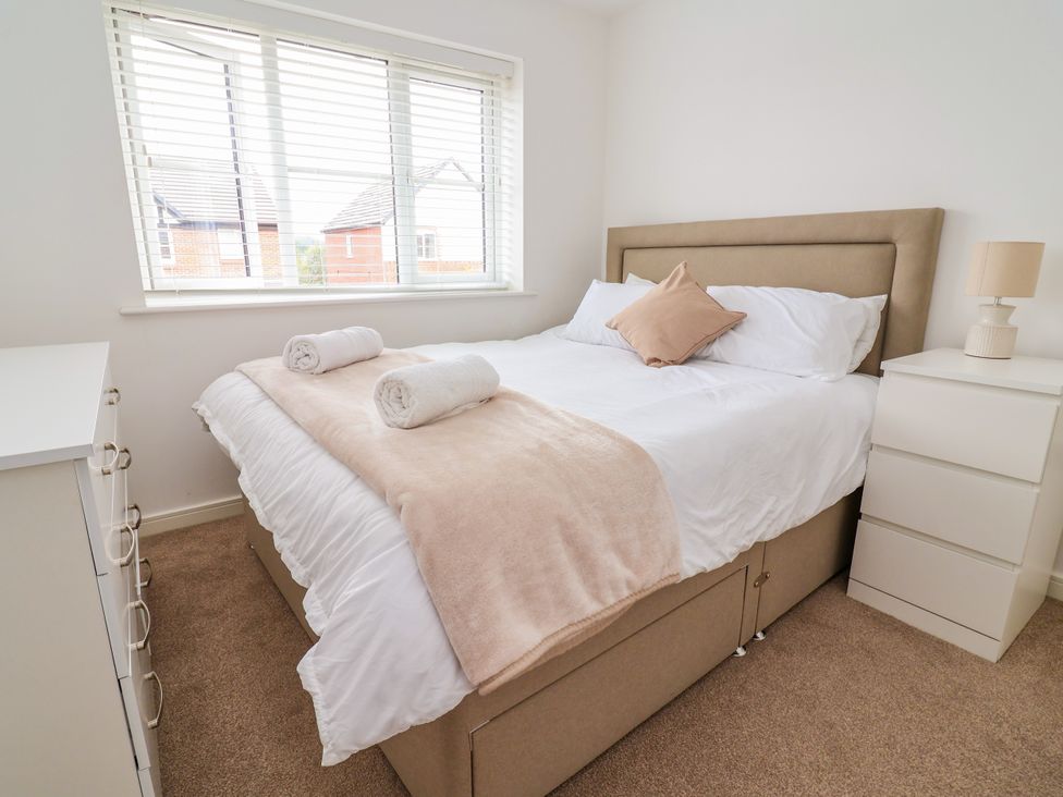A bedroom with a bed and a bedside table at 12 Corbetts Close in Crewe