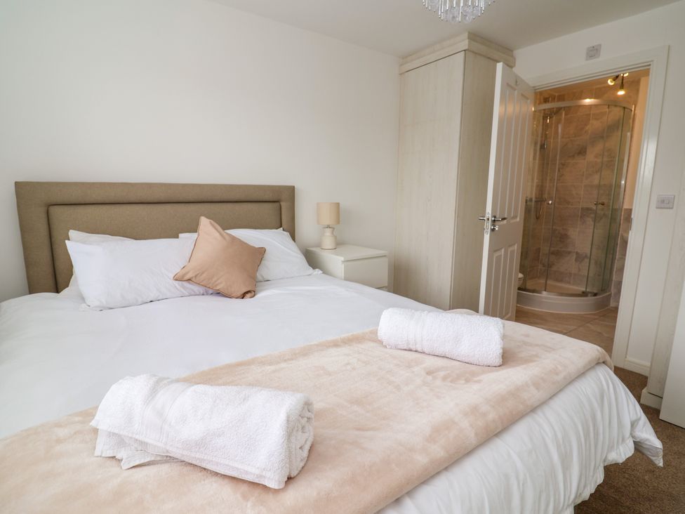 A bedroom with a bed and a shower room at 12 Corbetts Close Crewe
