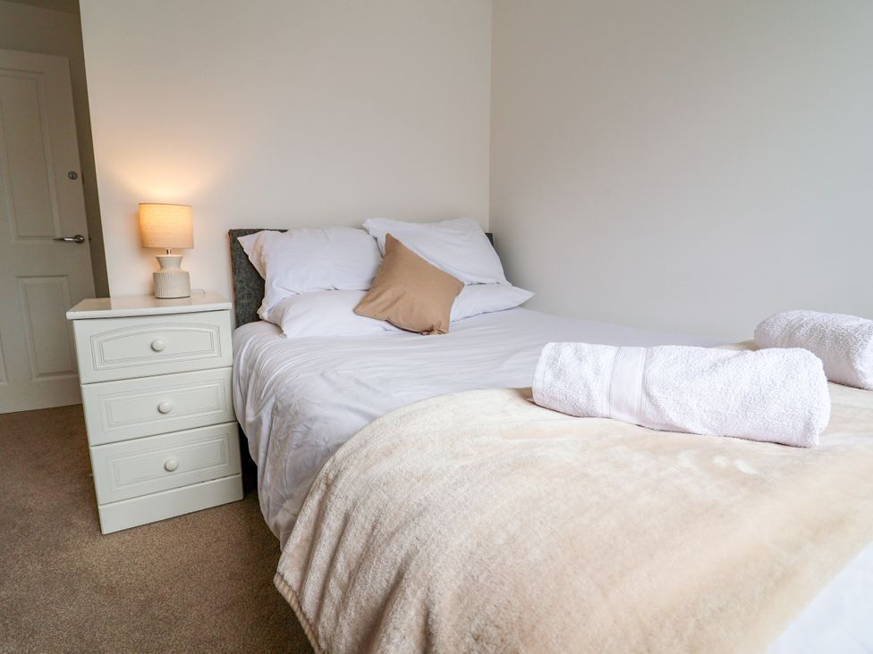 A bedroom with a bed and bedside cabinet at 12 Corbetts Close Crewe