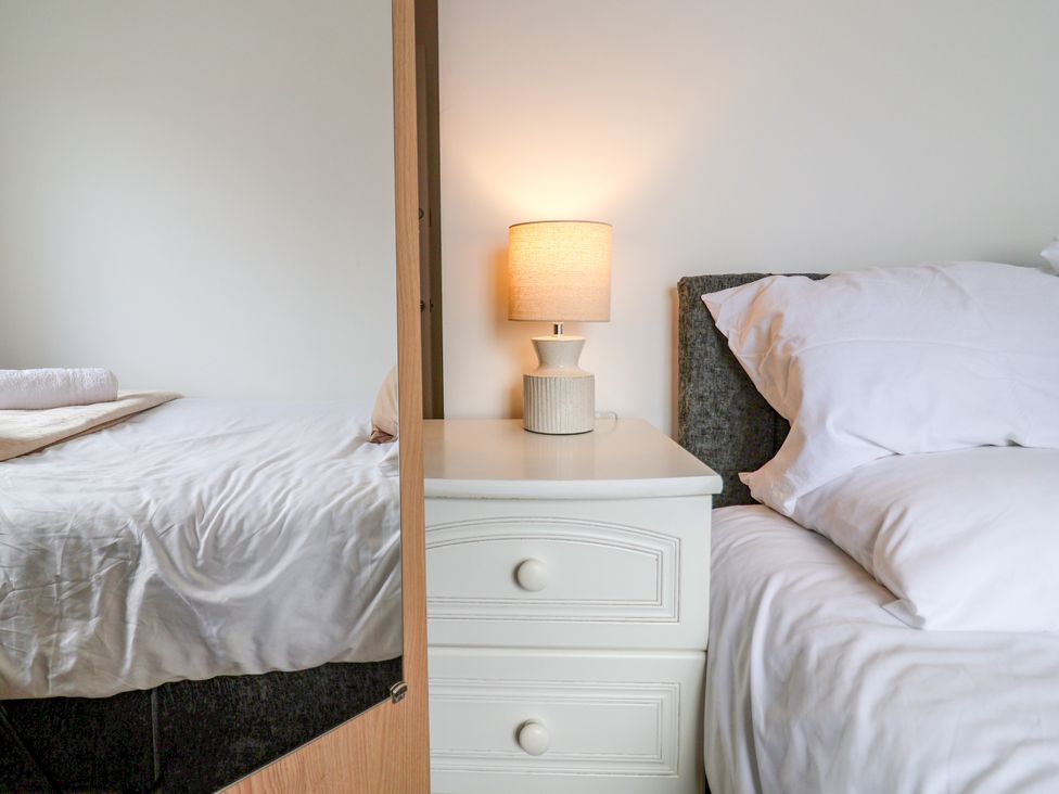 A bedroom with a bed and bedside table at 12 Corbetts Close in Crewe