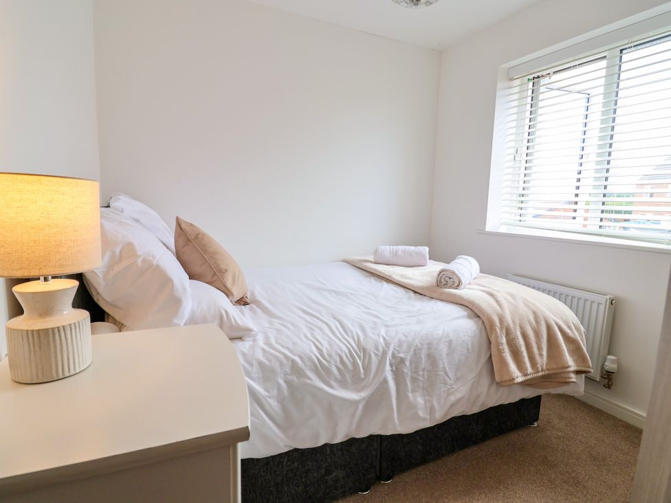A bedroom with a bed and lamp at 12 Corbetts Close Crewe