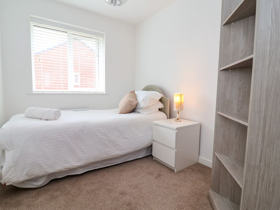A bedroom with a bed and lamp at 12 Corbetts Close Crewe