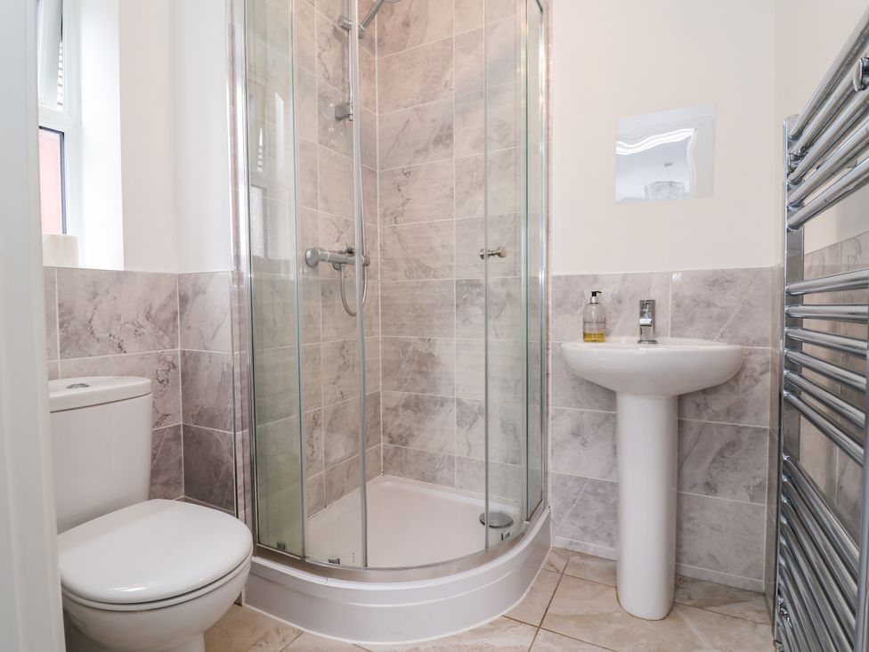 A bathroom with a shower, toilet and sink at 12 Corbetts Close in Crewe