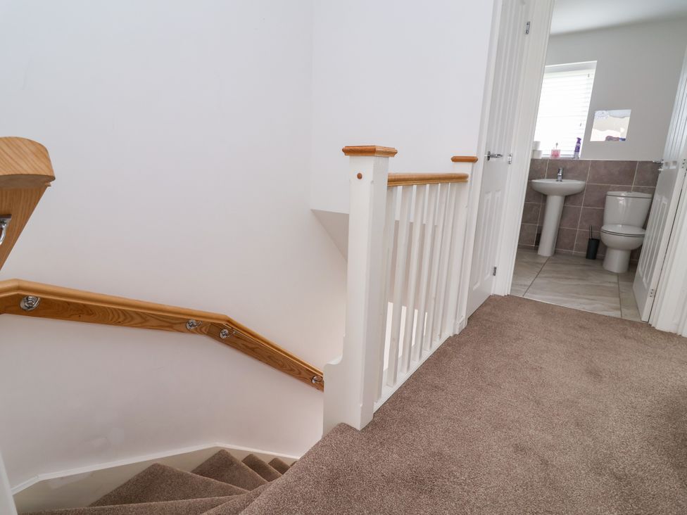 A hallway with stairs leading to a bathroom at 12 Corbetts Close in Crewe