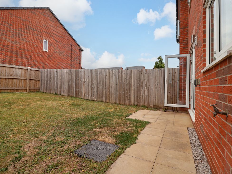 A garden with a fence and grass area at 12 Corbetts Close in Crewe