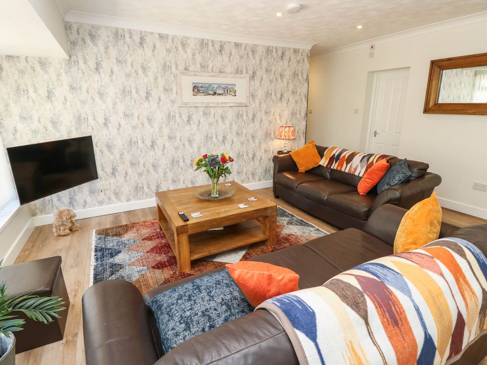 A living room with sofas and a coffee table at The Old Post Office in St. Lawrence near Ventnor