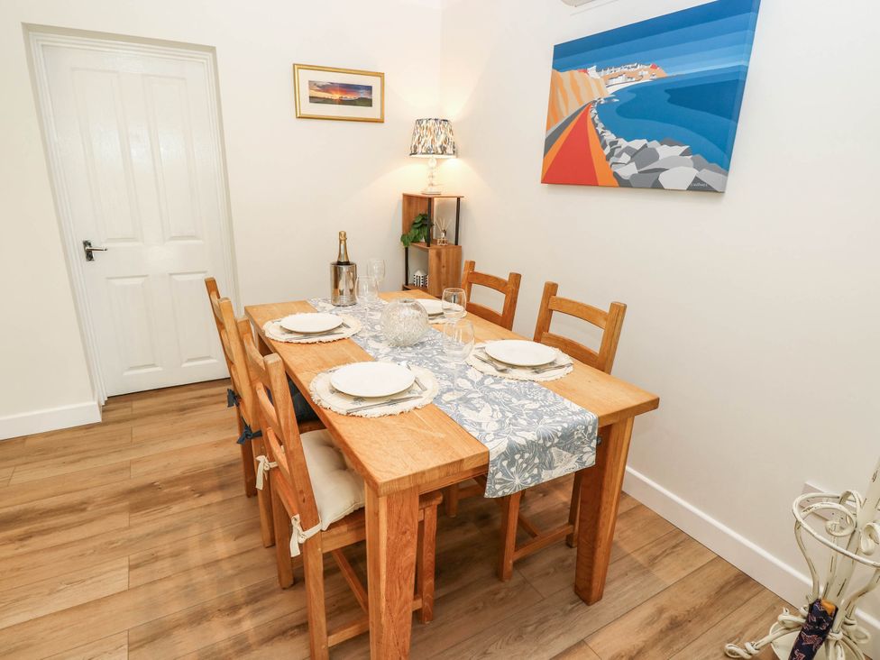 A dining room with a wooden table and chairs at The Old Post Office in St. Lawrence near Ventnor