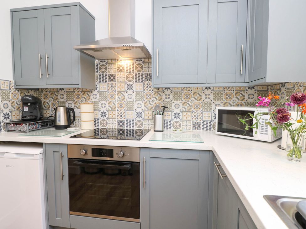 A kitchen with appliances and cabinets at The Old Post Office St. Lawrence near Ventnor