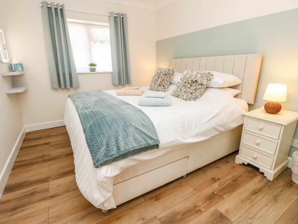 A bedroom with a bed and bedside table at The Old Post Office in St. Lawrence near Ventnor