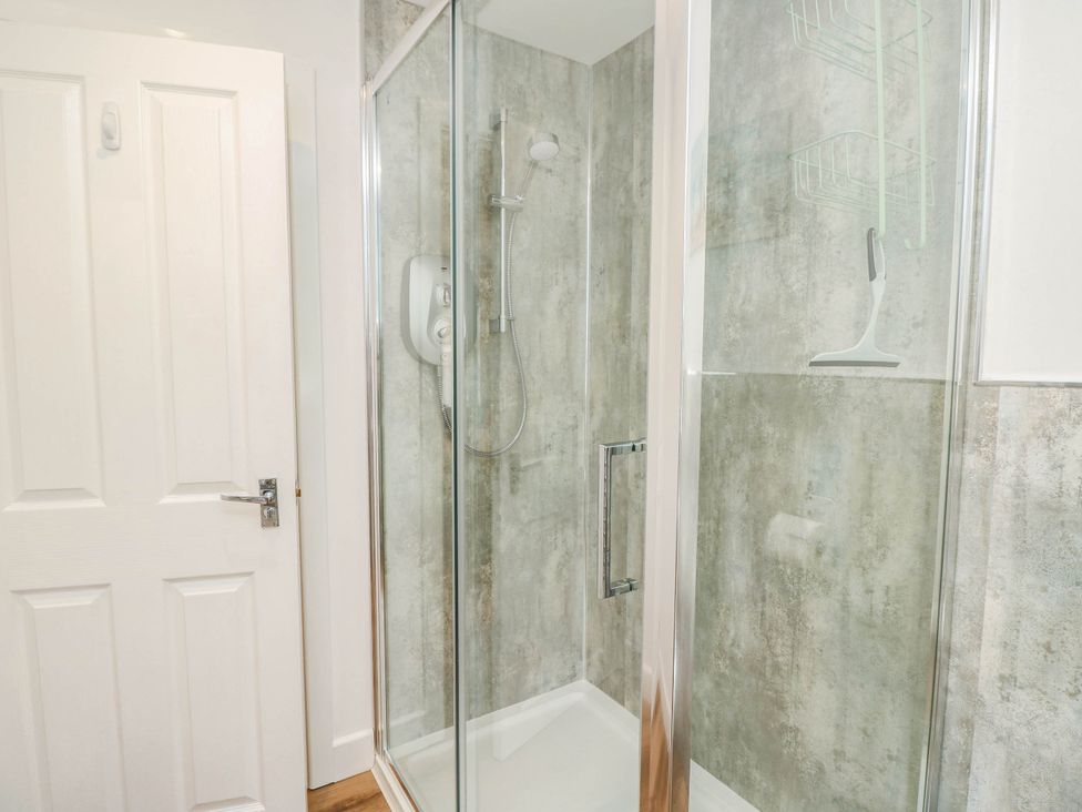 A shower with a sliding door and a bathroom door at The Old Post Office St. Lawrence near Ventnor