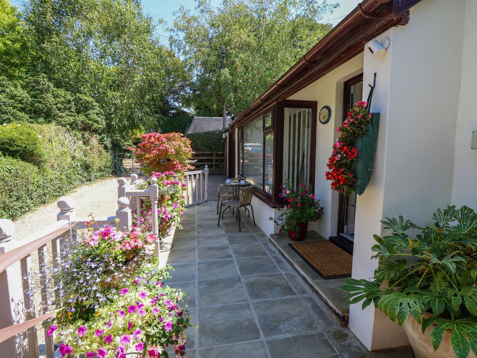 An outdoor area with flowers and seating at The Old Post Office St. Lawrence near Ventnor