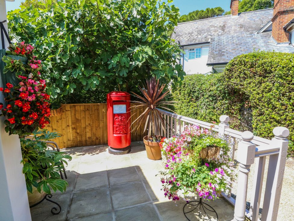 A garden area with a red post box and flowers at The Old Post Office St. Lawrence near Ventnor