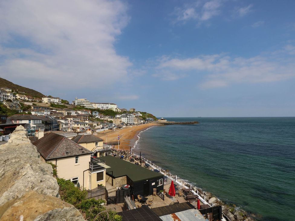 A view of a beach with houses and ocean at The Old Post Office St. Lawrence near Ventnor
