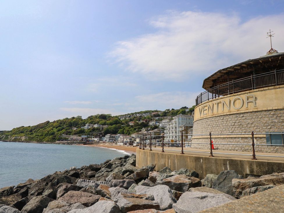 A seaside view with rocks and buildings along the beach at The Old Post Office St. Lawrence near Ventnor