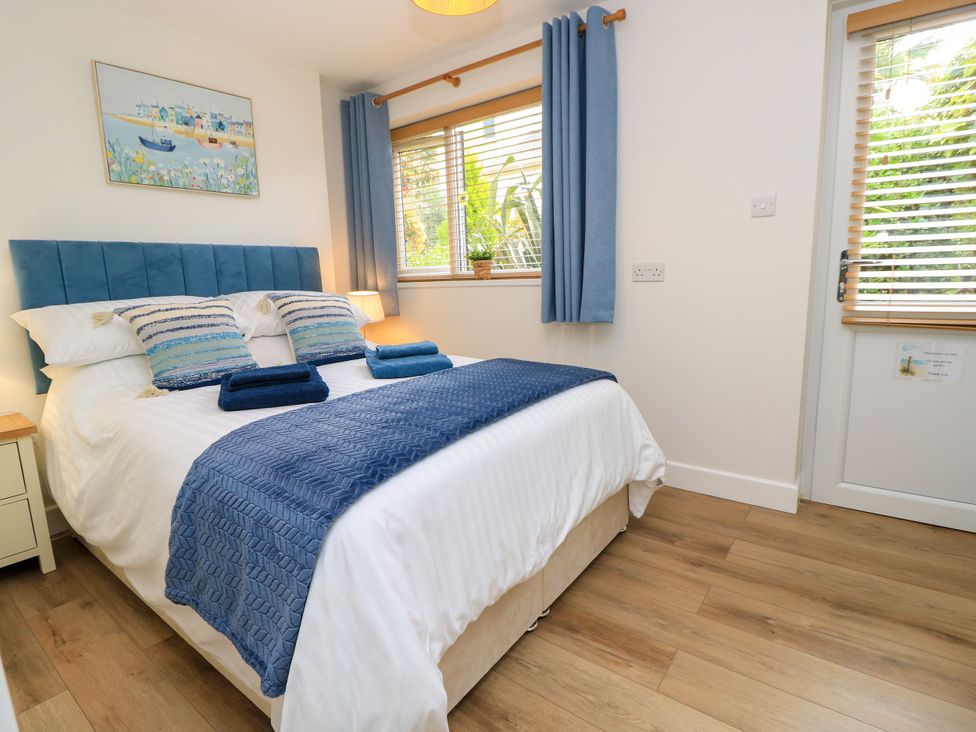 A bedroom with a bed and window at The Old Post Office St. Lawrence near Ventnor