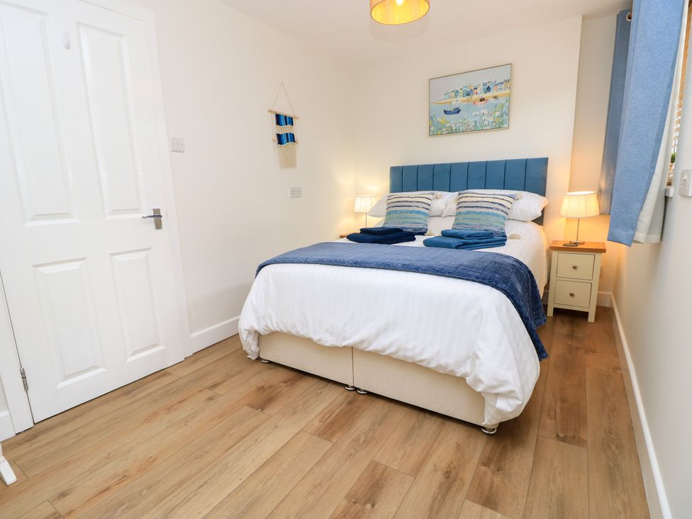 A bedroom with a bed and bedside tables at The Old Post Office St. Lawrence near Ventnor