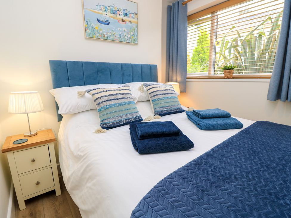 A bedroom with a bed and bedside table at The Old Post Office St. Lawrence near Ventnor