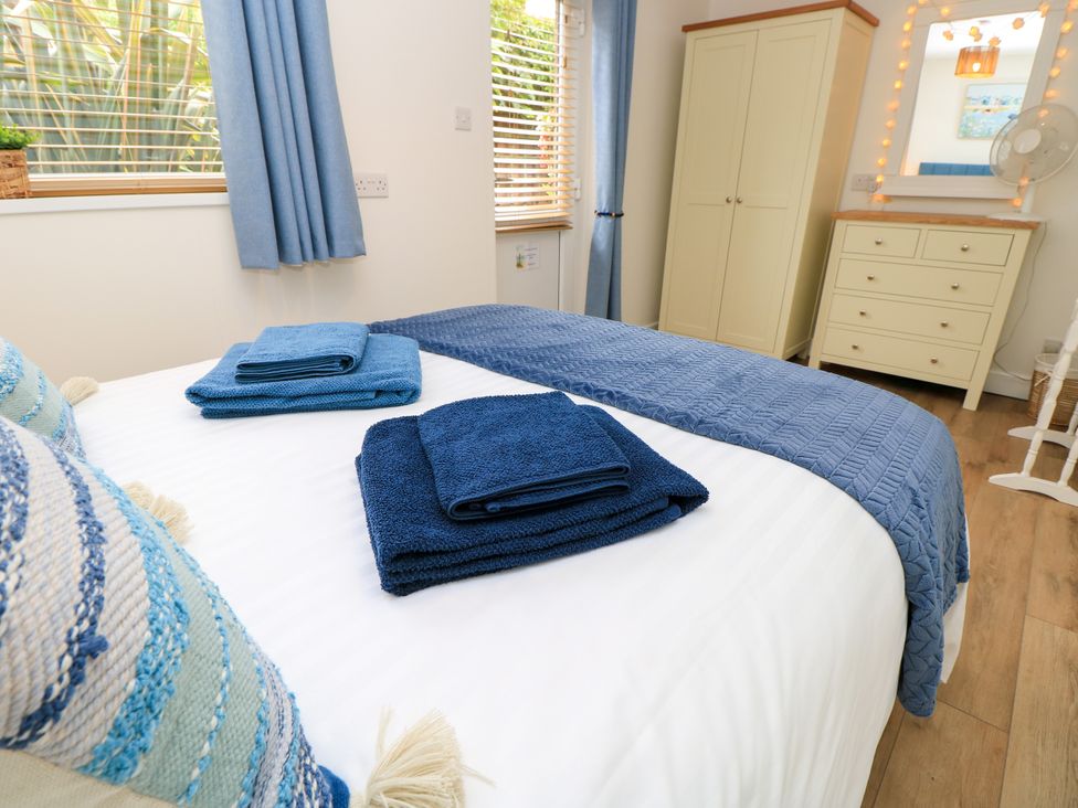 A bedroom with a bed and towels at The Old Post Office St. Lawrence near Ventnor