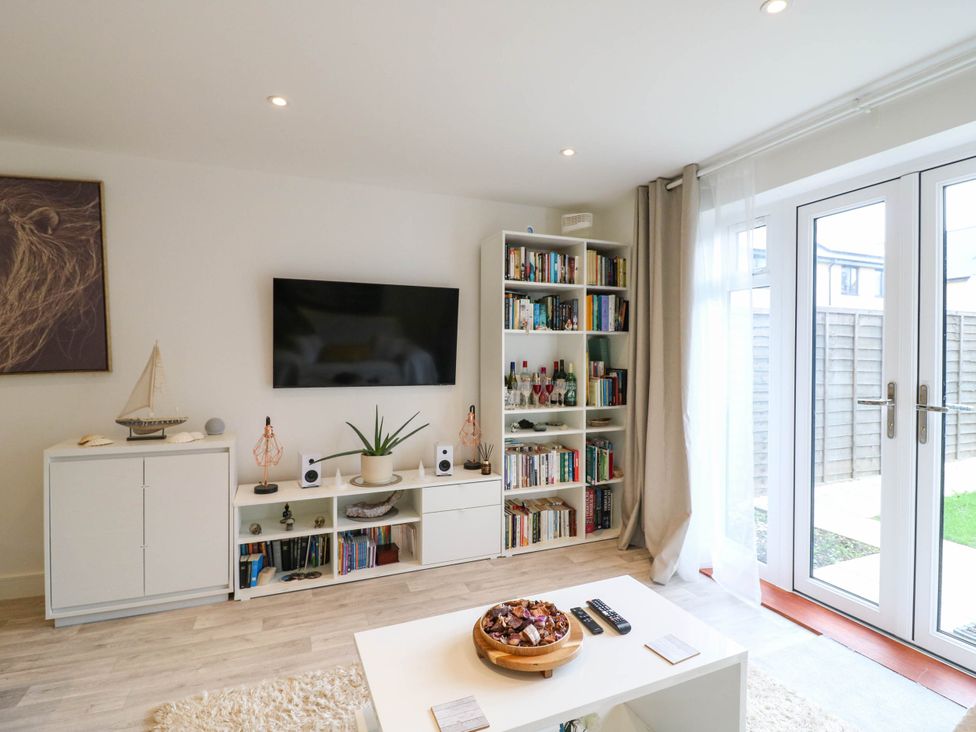 A living room with a bookshelf and television at Serenity House