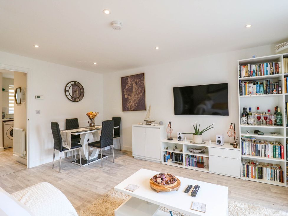 A living room with a dining table and bookshelf at Serenity House