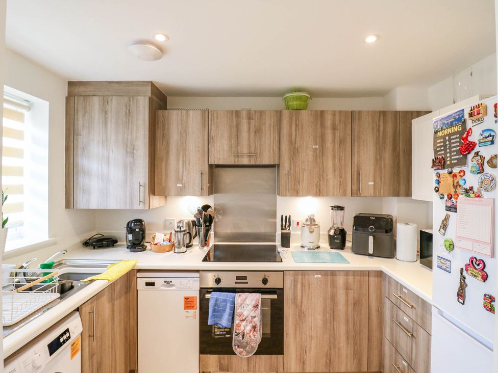 A kitchen with cabinets, sink, stove, and appliances at Serenity House