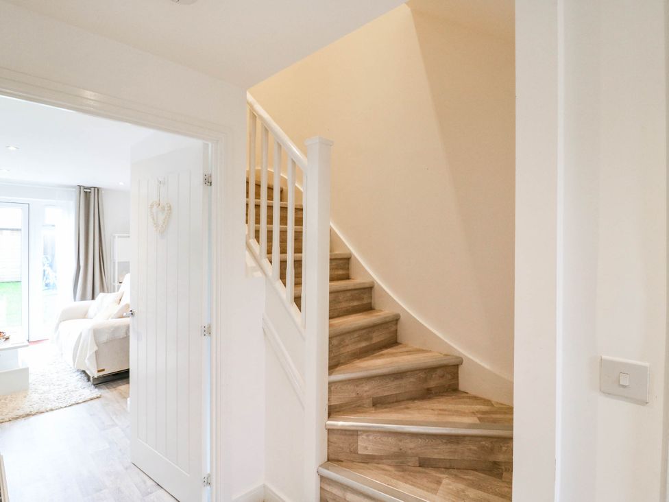 A hallway with a staircase and a living room visible at Serenity House