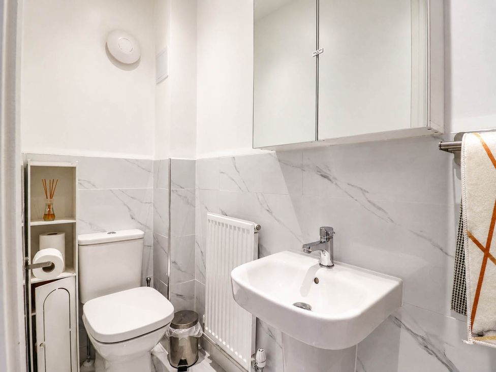 A bathroom with a sink, toilet and storage at Serenity House